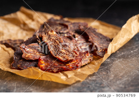 Beef jerky meat. Dried sliced meat on paper. 90534769