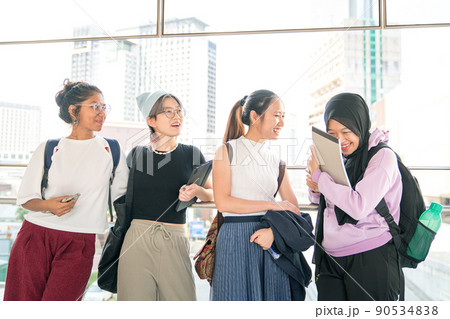Four multi-racial young women students laughing. Four multi-racial young women students laughing. 90534838