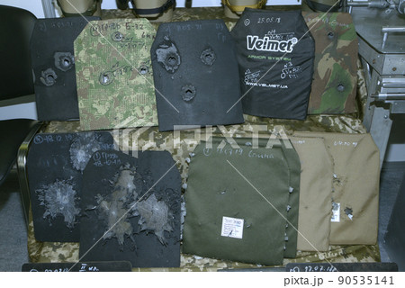 Body armor plates for army bulletproofs with bullet holes put on stand. Made by Velmet, Ukraine, tested and certified. Body armor plates for army bulletproofs with bullet holes put on stand. Made by Velmet, Ukraine, tested and certified. 90535141