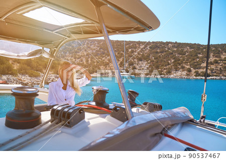 beautiful woman standing on yacht captain's bridge at sunny summer day 90537467