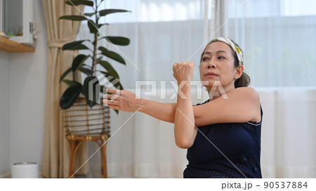 Shot of active senior lady doing stretching exercises during home workout. Healthy lifestyle concept 90537884