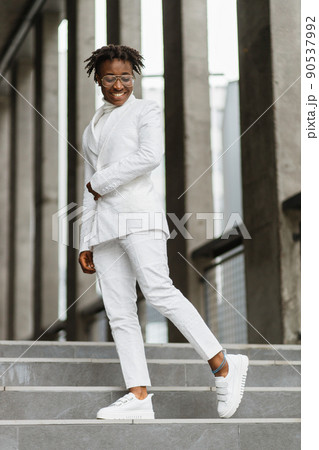 Portrait of a smiling african woman in glasses, walking in the modern city, smiling to camera. 90537992