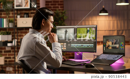 Graphic designer developing movie content on editing software, using creative multimedia for film production. Designing video motage with color gradient and visual effects on computer. 90538443