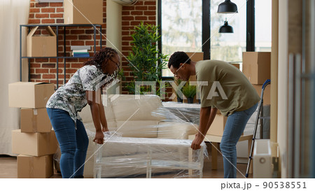 Married life partners decorating rented apartment flat with furniture, preparing living space to move in together and start new beginnings. Unpacking home decor at household property. Married life partners decorating rented apartment flat with furniture, preparing living space to move in together and start new beginnings. Unpacking home decor at household property. 90538551