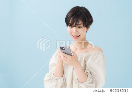 スマホを持つ女性　水色　青 90538552