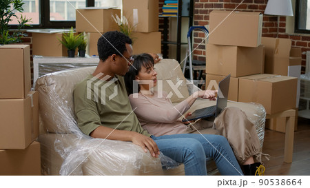 Married people moving in together and looking at home decor to buy online for new apartment property. Shopping interior furniture on laptop, after purchasing household investment. Married people moving in together and looking at home decor to buy online for new apartment property. Shopping interior furniture on laptop, after purchasing household investment. 90538664