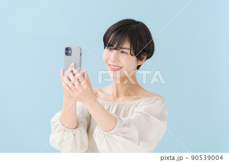 スマホを持つ女性　水色　青 90539004