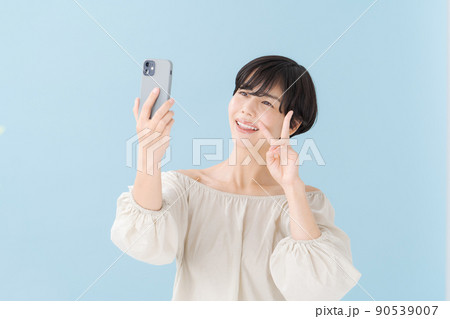 スマホを持つ女性 水色 青 スマホを持つ女性 水色 青 90539007