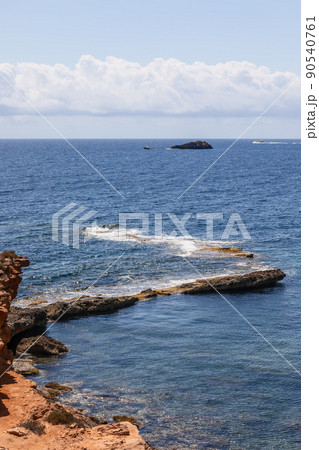 Vertical image of part of the coastal cliff smoothly disappearing underwater Vertical image of part of the coastal cliff smoothly disappearing underwater 90540761