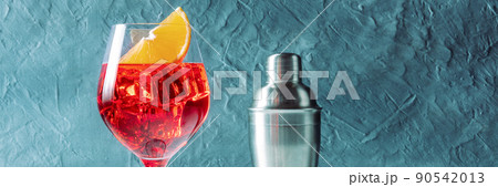 Aperol cocktail with an orange panorama, a side view with a shaker 90542013