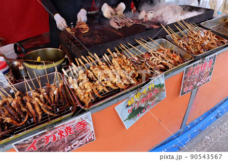 縁日の屋台（お祭りの屋台）の鉄板で焼かれているイカ焼きやゲソ焼き 90543567
