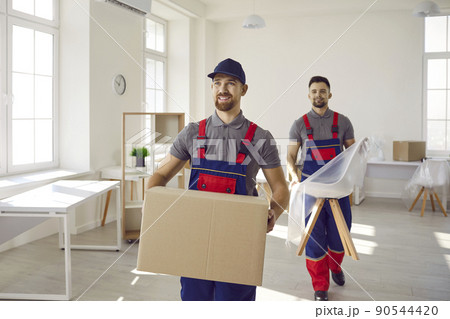 Two happy young workers from truck delivery service carrying furniture and boxes Two happy young workers from truck delivery service carrying furniture and boxes 90544420