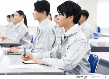 セミナーを受ける作業着を着た男女 90545224
