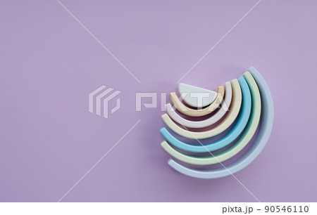 Children's wooden eco-friendly toys. A semicircle. Color Rainbow Colors: blue, light green, dark white on a gray background. View from above 90546110