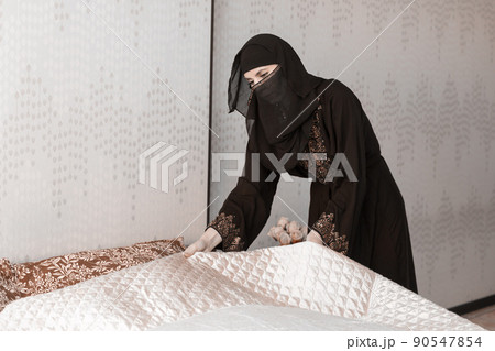Muslim woman doing housework. Refueling and cleaning pastels after sleep Muslim woman doing housework. Refueling and cleaning pastels after sleep 90547854
