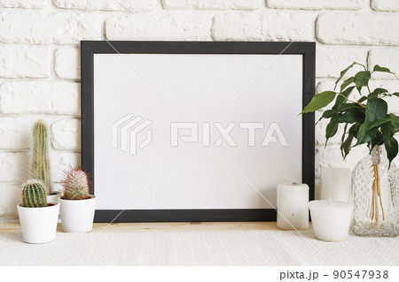 Square wooden photo frame and cactus plants on the table 90547938