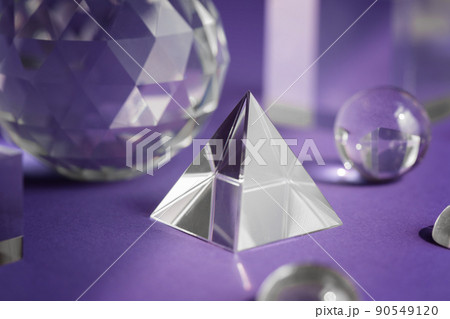 Crystal prism refracting light, magic crystals and pyramid, sphere and cube on purple background. Spiritual healing crystal practice. Feng Shui, good energy flow concept background.. Crystal prism refracting light, magic crystals and pyramid, sphere and cube on purple background. Spiritual healing crystal practice. Feng Shui, good energy flow concept background.. 90549120