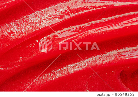 Red gel texture. Cosmetic clear liquid cream smudge. Skin care product sample closeup. Toothpaste or wax 90549255