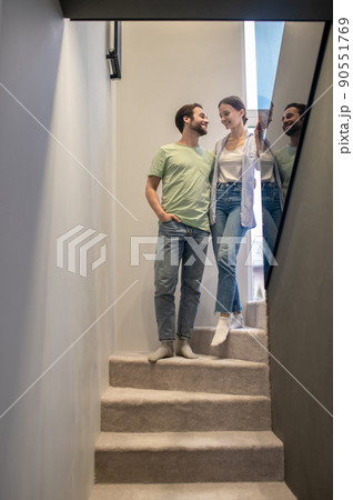 Man and woman looking at each other on stairs Man and woman looking at each other on stairs 90551769