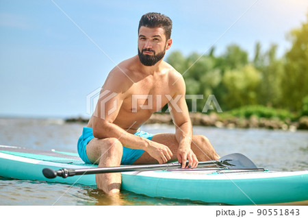 Well-built young man in blue shorts kayaking 90551843