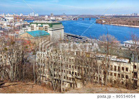 Cityscape of Kyiv in early spring with a view of the wide river Dnipro , bridges, old Podil on a sunny day. 90554054