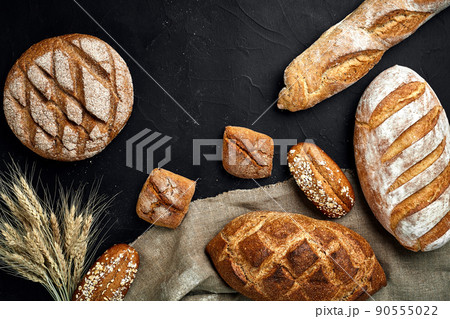 Bakery - gold rustic crusty loaves of bread and buns on black chalkboard background. 90555022