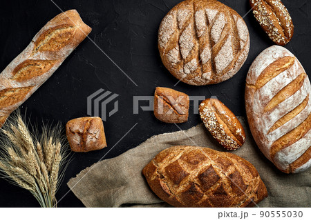 Bakery - gold rustic crusty loaves of bread and buns on black chalkboard background. 90555030