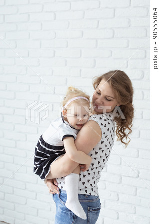 Baby with cochlear implant hearing aid having fun with her mother - deafness and diversity concept. Copy space and place for advertising 90555064