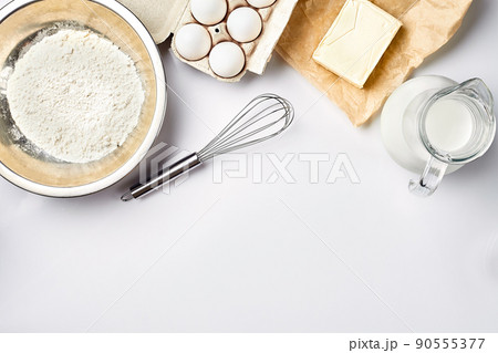Preparation of the dough. A measurement of the amount of ingredients in the recipe. Ingredients for the dough: flour, eggs, rolling pin, whisk, milk, butter, cream. Top view, space for text Preparation of the dough. A measurement of the amount of ingredients in the recipe. Ingredients for the dough: flour, eggs, rolling pin, whisk, milk, butter, cream. Top view, space for text 90555377