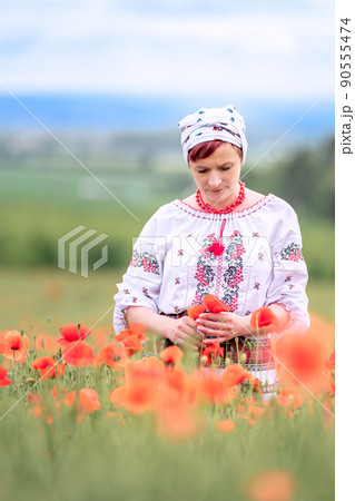 woman in Ukrainian national dress on a flowering poppy field 90555474