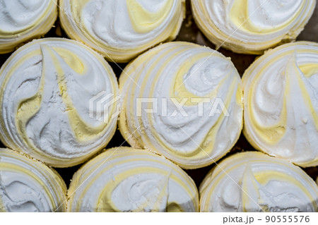 Marshmallows of different colors are laid out on trays. Fresh homemade marshmallow before packing. Marshmallows of different colors are laid out on trays. Fresh homemade marshmallow before packing. 90555576