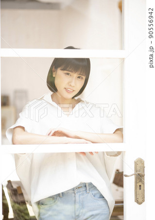 ガラス格子のドアから外を見る若い女性 ガラス格子のドアから外を見る若い女性 90556942
