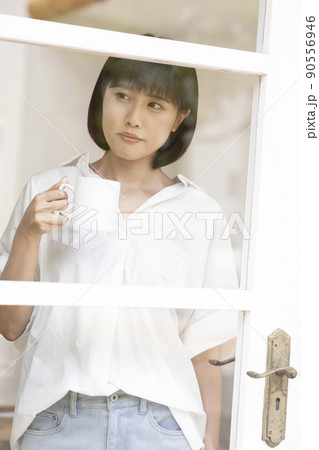 ガラス格子のドアから外を見る若い女性 ガラス格子のドアから外を見る若い女性 90556946