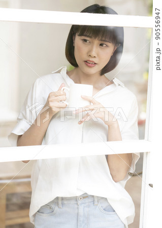 ガラス格子のドアから外を見る若い女性 ガラス格子のドアから外を見る若い女性 90556947