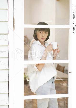 ガラス格子のドアから外を見る若い女性 ガラス格子のドアから外を見る若い女性 90556950