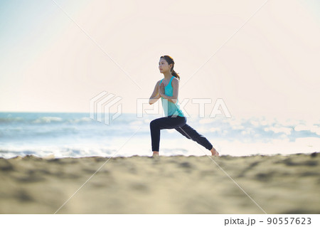 砂浜でヨガをする若い女性 90557623