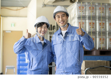 倉庫内作業スタッフイメージ　作業服を着た笑顔の男女 90559352