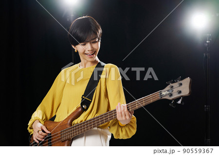 女性　ギタリスト　黒背景 90559367