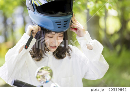 森でヘルメットを被る(脱ぐ)バイク女子 90559642