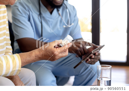 Male health worker with digital tablet discussing with caucasian senior woman over medication dose Male health worker with digital tablet discussing with caucasian senior woman over medication dose 90560551