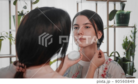 A young woman creates the image of a geisha for a girl. Makeup. Creating an image for an event 90560849