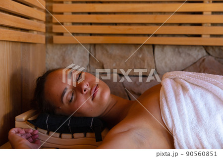 Caucasian young woman in a bathrobe relaxing in the sauna 90560851