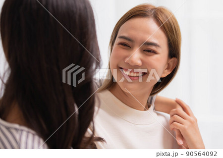 Happy LGBT lesbian couple lesbian embracing and looking together with love and romance on bed. 90564092