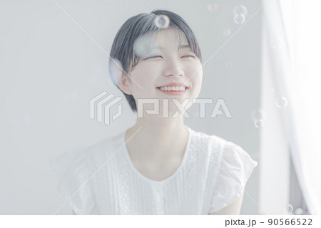 シャボン玉とショートヘアの若い女性 90566522