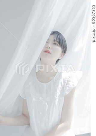 白いカーテンとショートヘアの若い女性 白いカーテンとショートヘアの若い女性 90567855