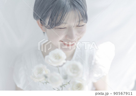 白いバラを持つショートヘアの若い女性 白いバラを持つショートヘアの若い女性 90567911