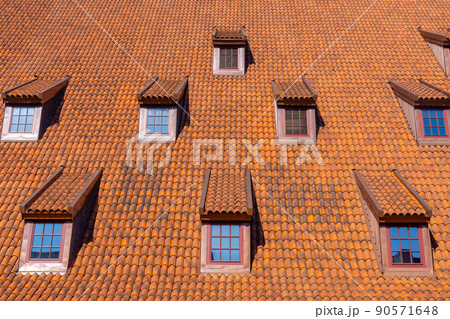 Many small windows on a red roof covered with tiles in the old town of Gdansk 90571648