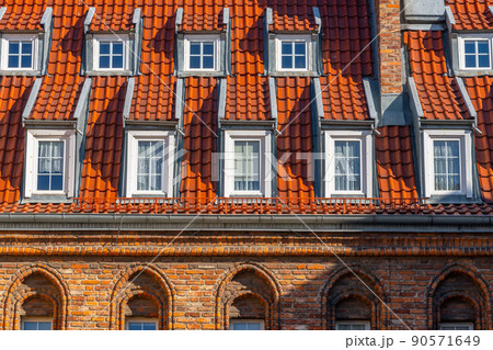 Many small windows on a red roof covered with tiles in the old town of Gdansk 90571649