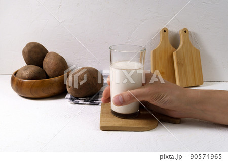Alternative vegetable vegan potato milk in a glass and potato. Vegetarian food. Alternative non dairy drink Alternative vegetable vegan potato milk in a glass and potato. Vegetarian food. Alternative non dairy drink 90574965