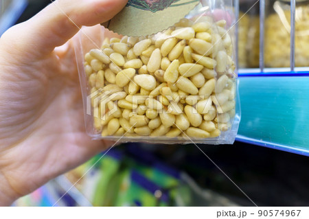 Packaged snacks pine nuts on the shelves of the hypermarket. A healthy snack. Selective focus Packaged snacks pine nuts on the shelves of the hypermarket. A healthy snack. Selective focus 90574967